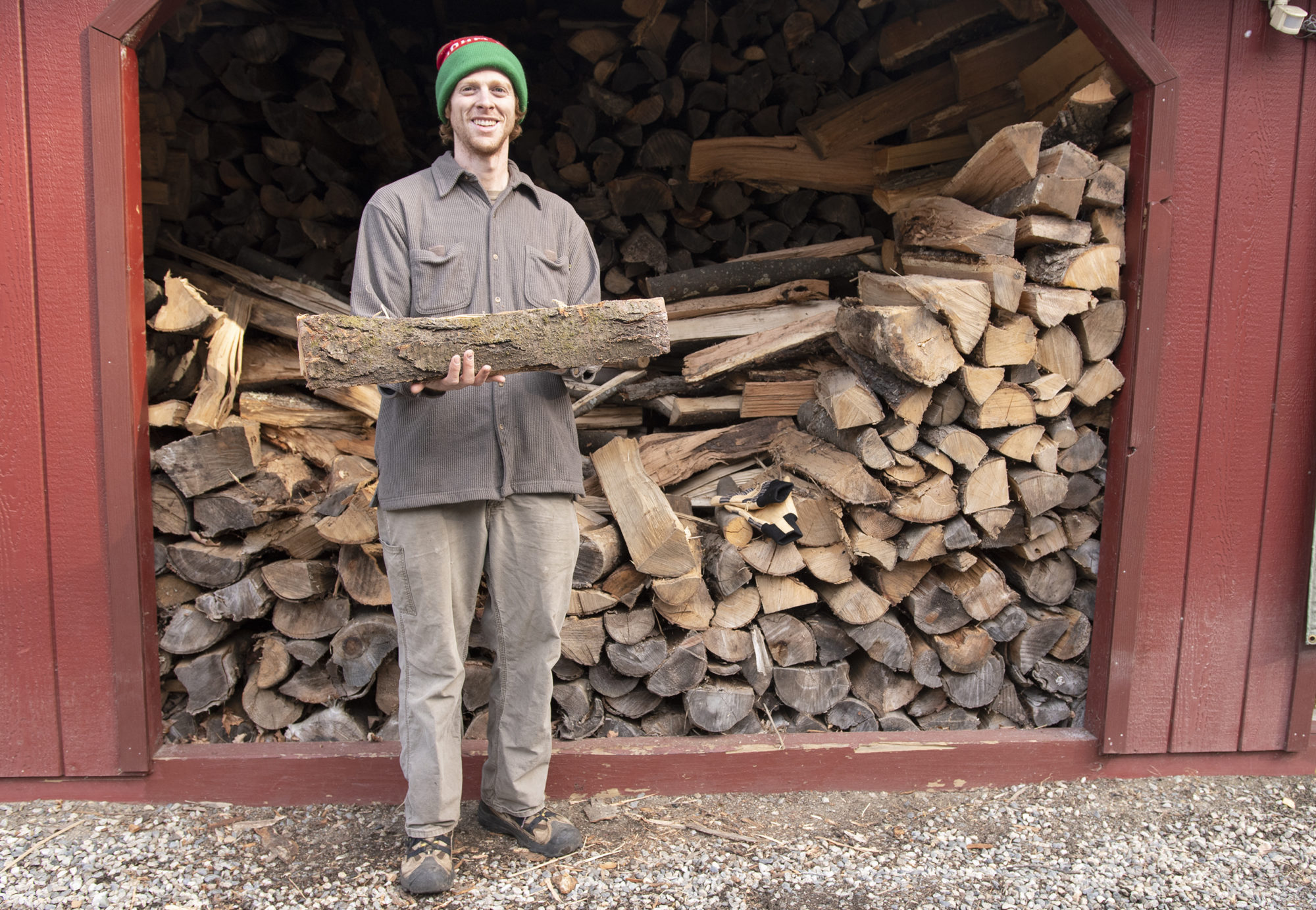 Vermont Vermont Woodworker Jake Checani stands with firewood harvested behind Vermont Woods Studios