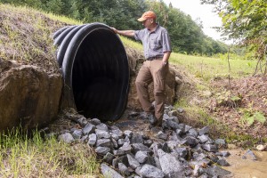 Tim Morton inspects a new culvert that helps carry water from numerous drainages from South Mountain in Okemo State Forest. Photo by Erica Houskeeper.