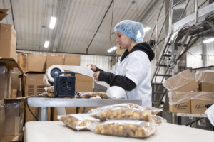 An employee labels boxes for Olivia’s Croutons in Brandon. Photo by Erica Houskeeper.