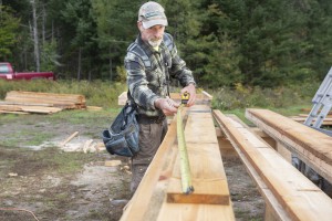 Business partner John Plowden constructs a pole barn, which is using timber that is milled on site. Photo by Erica Houskeeper.