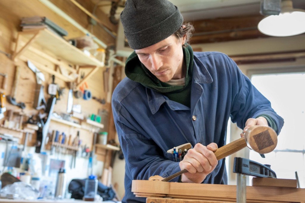 Furniture maker Nick English creates a sleigh armchair at ShackletonThomas in Bridgewater. Photo by Erica Houskeeper.