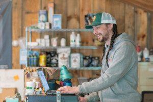 Diego Morales works at the register in the Vermont Grow Barn in Brattleboro. Vermont Grow Barn, a grow supply store, was established in 2021 by Scott Sparks as a sister store to his CBD shop Vermont Hempicurean. Photo by Erica Houskeeper.