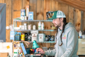 Diego Morales works at the register in the Vermont Grow Barn in Brattleboro. Vermont Grow Barn, a grow supply store, was established in 2021 by Scott Sparks as a sister store to his CBD shop Vermont Hempicurean. Photo by Erica Houskeeper.