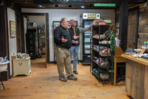 Vermont Hempicurean owner Scott Sparks shows Vermont Sustainable Jobs Fund business coach Victor Morrison a display of CBD products. Photo by Erica Houskeeper.