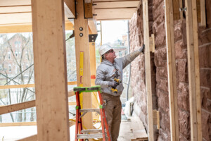 An employee from Bread Loaf Corporation works on the addition, which will keep with the historic nature of the original building that was built in 1890. Photo by Erica Houskeeper.