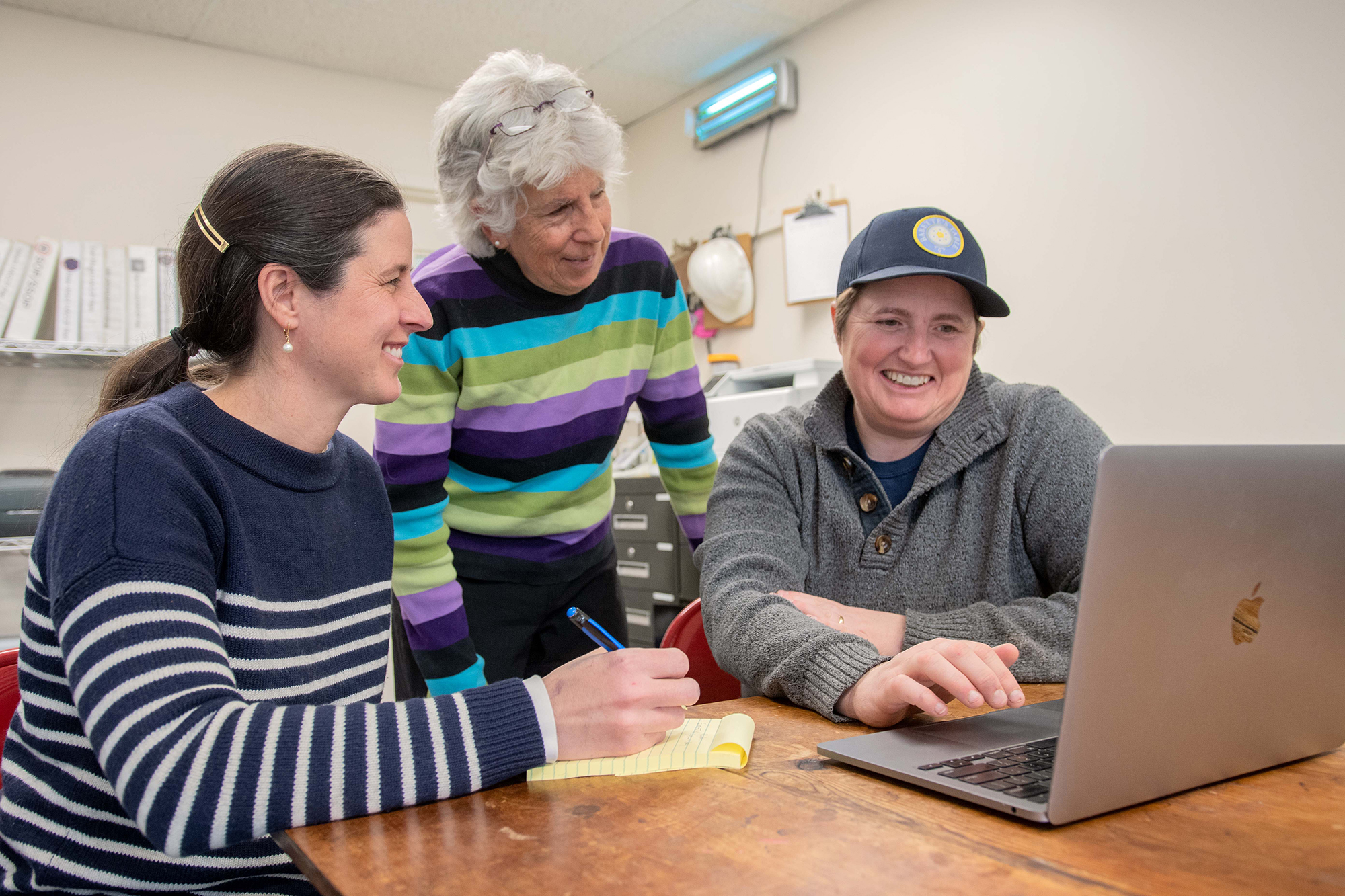 Vermont Sustainable Jobs Fund business coach Jean Kissner, center, reviews business projections with Julie Morton and Erika Lynch. Photo by Erica Houskeeper.