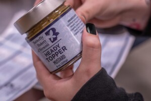 An employee places a label on Heady Topper Mustard at Butterfly Bakery’s cannery in Barre. Photo by Erica Houskeeper.