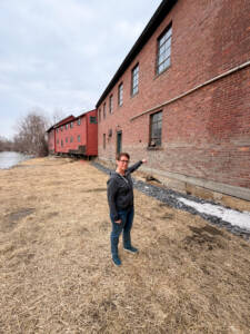 Gina Akley of Trow & Holden shows where the water line was during the devastating flooding in 2023. 