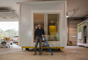 Michael Zembrowski of Up End This standing in front of one of the company’s Satellites, a modular home system designed to meet the evolving needs of modern living. Photo by Erica Houskeeper.